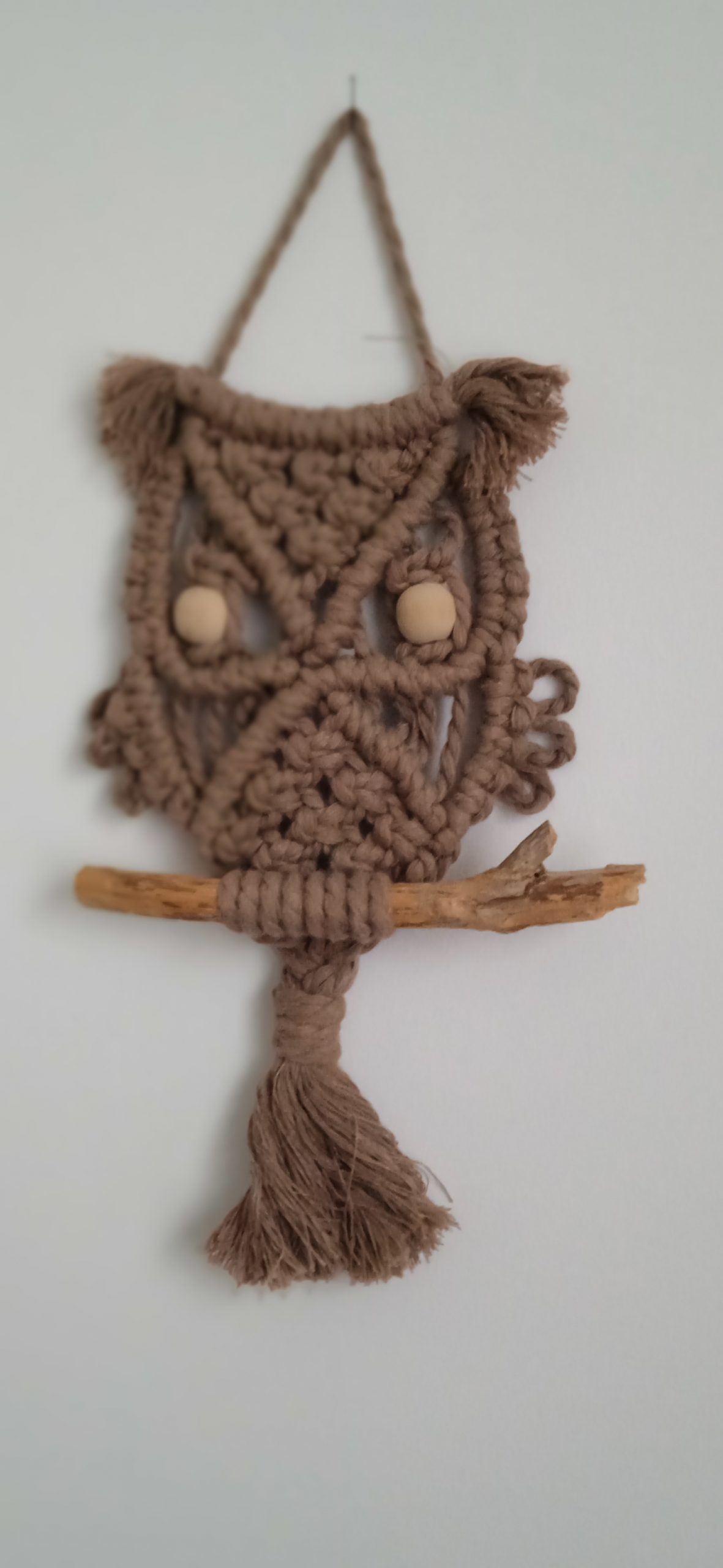 Suspension murale artisanale en macramé représentant une chouette, avec perles de bois