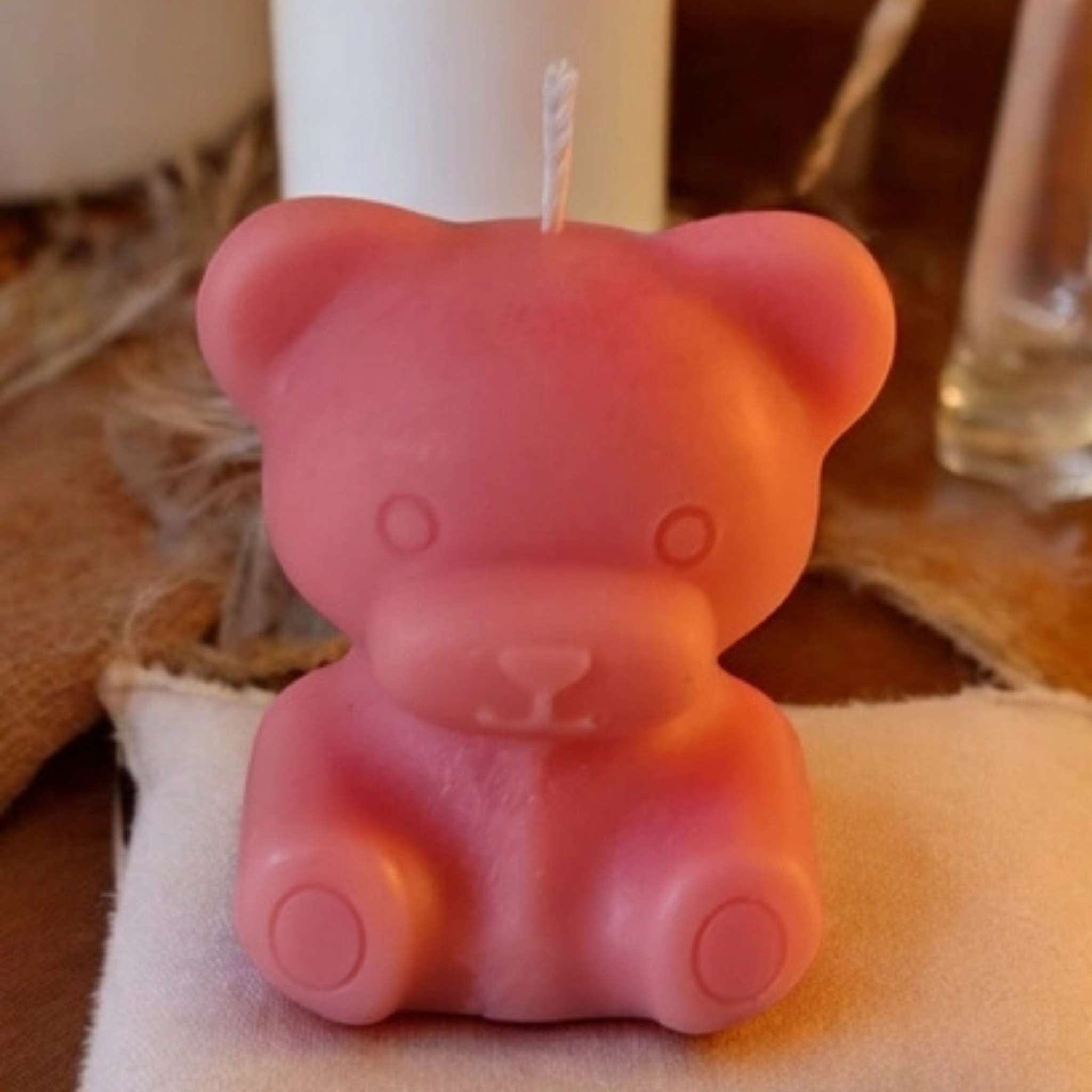 Bougie décorative en forme d’ourson rose posée sur une coupelle – fabrication artisanale française