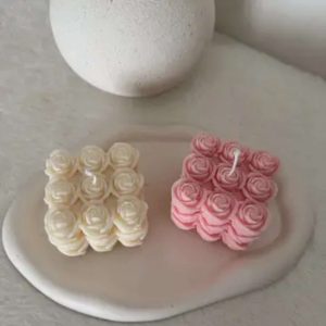 Bougie cube artisanale parfumée Bouquet de Roses en cire de colza bio, fabriquée à la main en France, posée sur un support naturel.