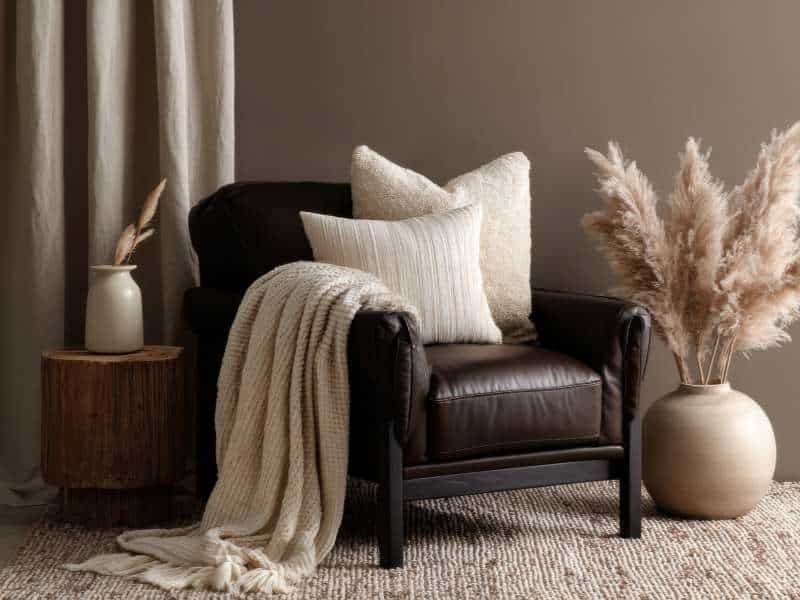 “Coin lecture automnal avec fauteuil, plaid en laine et coussin velours”