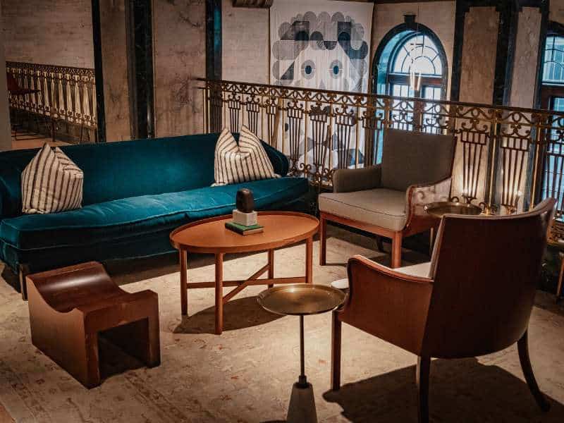 “Fauteuil en velours et table basse en bois brut pour un salon automnal élégant”