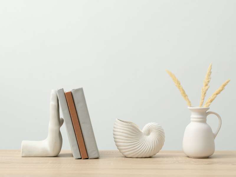 Trois objets décoratifs mis en scène sur une étagère pour illustrer la règle du 3