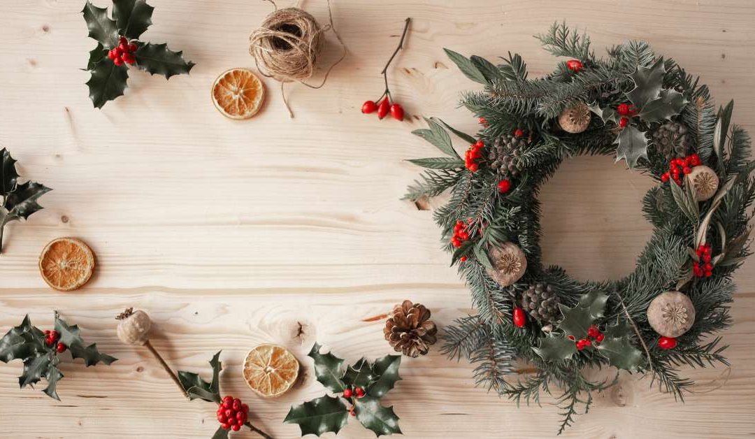 Couronne de Noël naturelle asymétrique décorée de sapin, eucalyptus, oranges séchées et pommes de pin