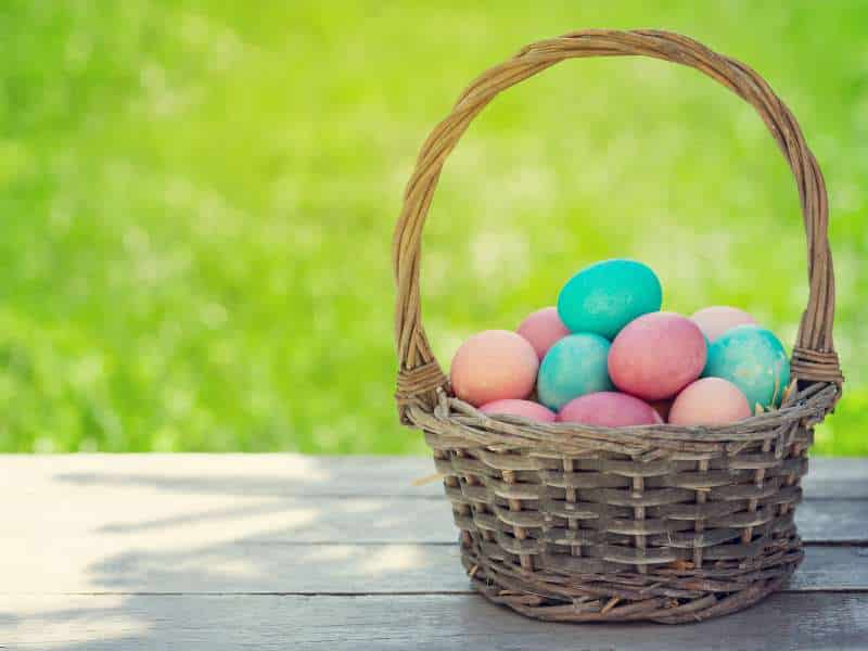 panier en osier avec œufs décoratifs pour pâques